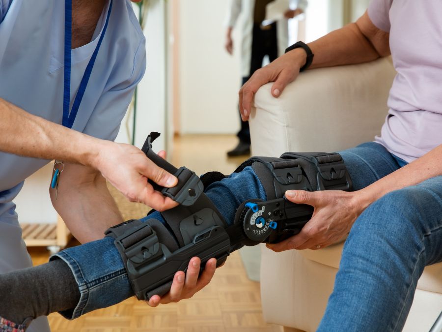 Fisioterapista che utilizza il dispositivo Kinetec per la mobilizzazione del ginocchio dopo l’intervento di protesi.